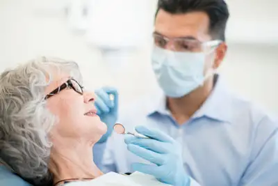 Older woman sitting with dentist.