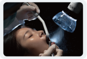 A woman being treated while the extraoral suction system is in use